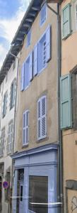 a building with blue doors and windows on a street at Joyau historique 101 in Aurillac
