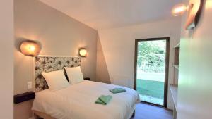 a bedroom with a large white bed with a window at Château de la Malmaison in Champillon
