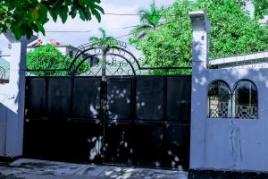 a black fence with a gate in front of a house at Ziwani House in Mwanza