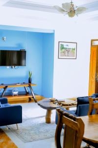 a living room with blue walls and a table and chairs at Ziwani House in Mwanza