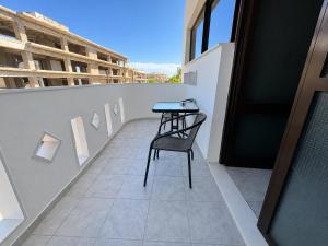 a table and chair on the balcony of a building at Aleka Apartments in Kos