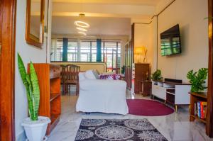 a living room with a white couch and a table at Bright Diani Studio with King Bed, 2min to Beach in Diani Beach