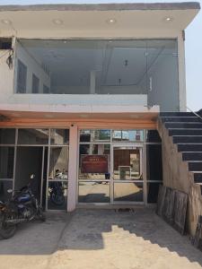 a motorcycle parked in front of a building with glass doors at Hotel Shree Sanwaliya INN in Ayodhya