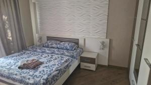 a small bedroom with a bed with blue and white sheets at Старе місто, центр in Lutsk