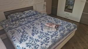 a bed with a blue and white comforter with a purse on it at Старе місто, центр in Lutsk