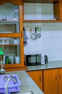 a kitchen with a sink and a microwave at Ziwani House in Mwanza