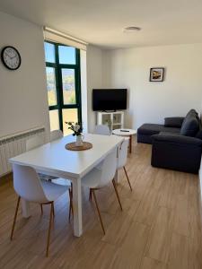 a living room with a white table and chairs at PortoHome 2 in Portomarin