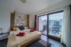 a bedroom with a bed and a large window with a balcony at Budapest Center Residence in Budapest