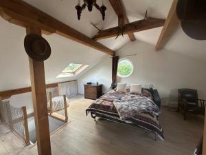 an attic bedroom with a bed and a window at Chez Clémence & Baptiste in Buhl-Lorraine