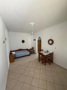 a living room with a bed and a table at Tiki Rooms in Marathokampos