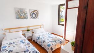 a bedroom with two beds and a window at Fwt Relax Bungalow in Playa de las Americas +63 photos