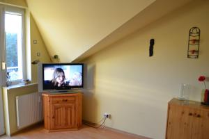 telewizor siedzący na drewnianym stoliku w pokoju w obiekcie Apartament Paula w Ustce