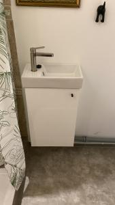 a white sink in a bathroom next to a bed at Bruno māja in Strenči