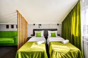 two beds in a room with green curtains at APART-HOTEl 95 in Almaty