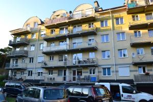 duży budynek z zaparkowanymi przed nim samochodami w obiekcie Apartament Paula w Ustce
