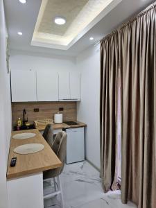 a kitchen with a table with chairs and a counter at Studio centar Lazic 1 in Šid +10 photos