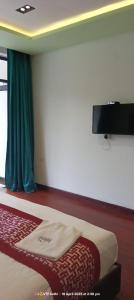 a bedroom with a bed with a television on the wall at Hotel San Andreas Amar in Kodaikānāl