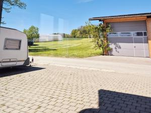 a white trailer parked next to a garage at JM Swiss Space Hostel in Langrickenbach
