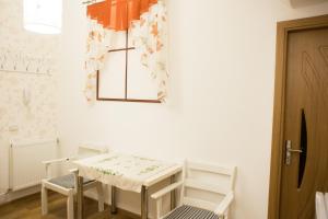 ティミショアラにあるElegance Residenceの窓付きの客室で、白いテーブルと椅子が備わります。