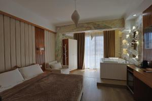 a bedroom with a bed and a bathroom with a tub at Ilio Boutique Hotel in Ksamil +268 photos