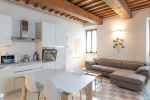 a kitchen and living room with a white table and chairs at TUSCANFLAT Castle in Scrofiano