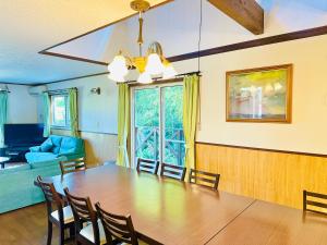 a dining room with a large wooden table and chairs at ラシェール 伊豆 ガーデンテラス AWA Resort in Ito