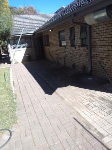 a brick house with a driveway in front of it at Star Contractors Accodation with self catering in Mahikeng