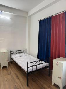 a small bedroom with a bed and a curtain at Nasa in Panchanai