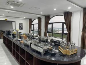 a counter with several sinks in a room with windows at Army Hotel in Yen
