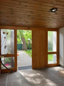 an open door of a house with windows and a patio at Villa Pdorf in Perchtoldsdorf