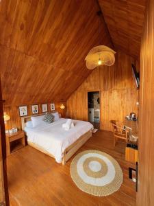 a bedroom with a large bed and a wooden ceiling at Dynasty Glamping Bedugul in Bedugul