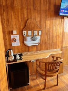 a wooden wall with a wooden table and a chair at Dynasty Glamping Bedugul in Bedugul