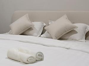 two white beds with white pillows on top of them at Juichi Homestay in Kluang