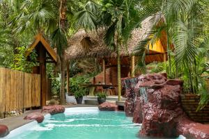 a pool with a waterfall in a resort at The Namkhan, a Small Luxury Hotel of the World in Luang Prabang