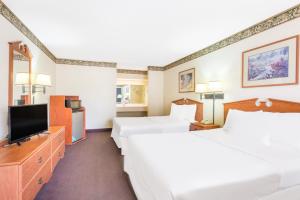 A bed or beds in a room at Days Inn & Suites by Wyndham Marshall