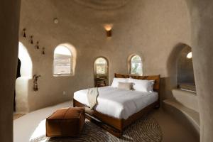 a bedroom with a bed and two arched windows at Sandora Domes - Architectural Retreat Near National Park in Joshua Tree +88 photos