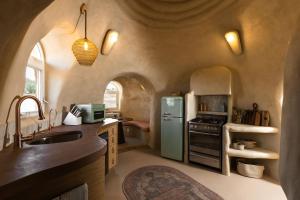 a kitchen with a sink and a refrigerator at Sandora Domes - Architectural Retreat Near National Park in Joshua Tree