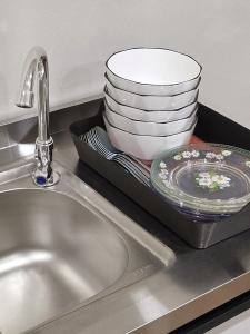 a sink with a plate and a stack of dishes at Juichi Homestay in Kluang +46 photos