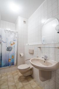 ein Bad mit einem Waschbecken, einem WC und einer Dusche in der Unterkunft Hotel Gröbern am See in Gröbern