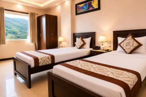 a hotel room with two beds and a window at Platinum Royal Excellency in Udaipur +9 photos