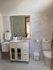 a bathroom with a sink and a toilet and a mirror at PortoHome 2 in Portomarin +30 photos