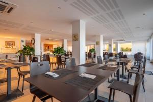 a dining room with tables and chairs in a restaurant at Hotel Porto Calpe in Calpe