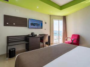 a hotel room with a bed and a desk and a table at Hotel Porto Calpe in Calpe