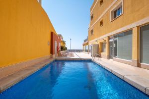 a swimming pool in front of a building at Hotel Porto Calpe in Calpe