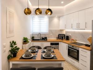 a kitchen with white cabinets and a wooden table at Belvedere Penthouse Suite in Tríkala
