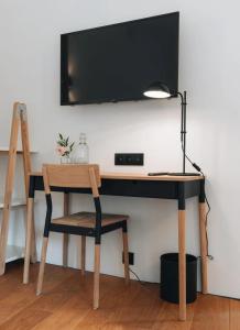 a desk with a chair and a television on a wall at The Grand Indradhar Resort Dharamshala in Dharamshala
