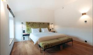 a bedroom with a large white bed and a table at The Grand Indradhar Resort Dharamshala in Dharamshala