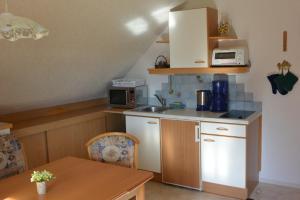 a small kitchen with a table and a microwave at Ferienwohnung Pöreiterhof in Tauplitz