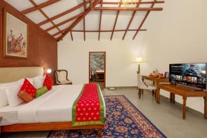 a bedroom with a bed and a desk and a television at Fort JadhavGADH -A GADH Heritage Hotel in Pune