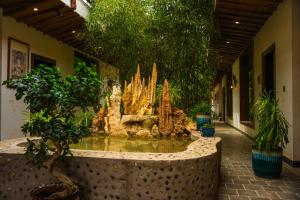 a fountain in the middle of a building with plants at 唐韵驿馆 in Dunhuang